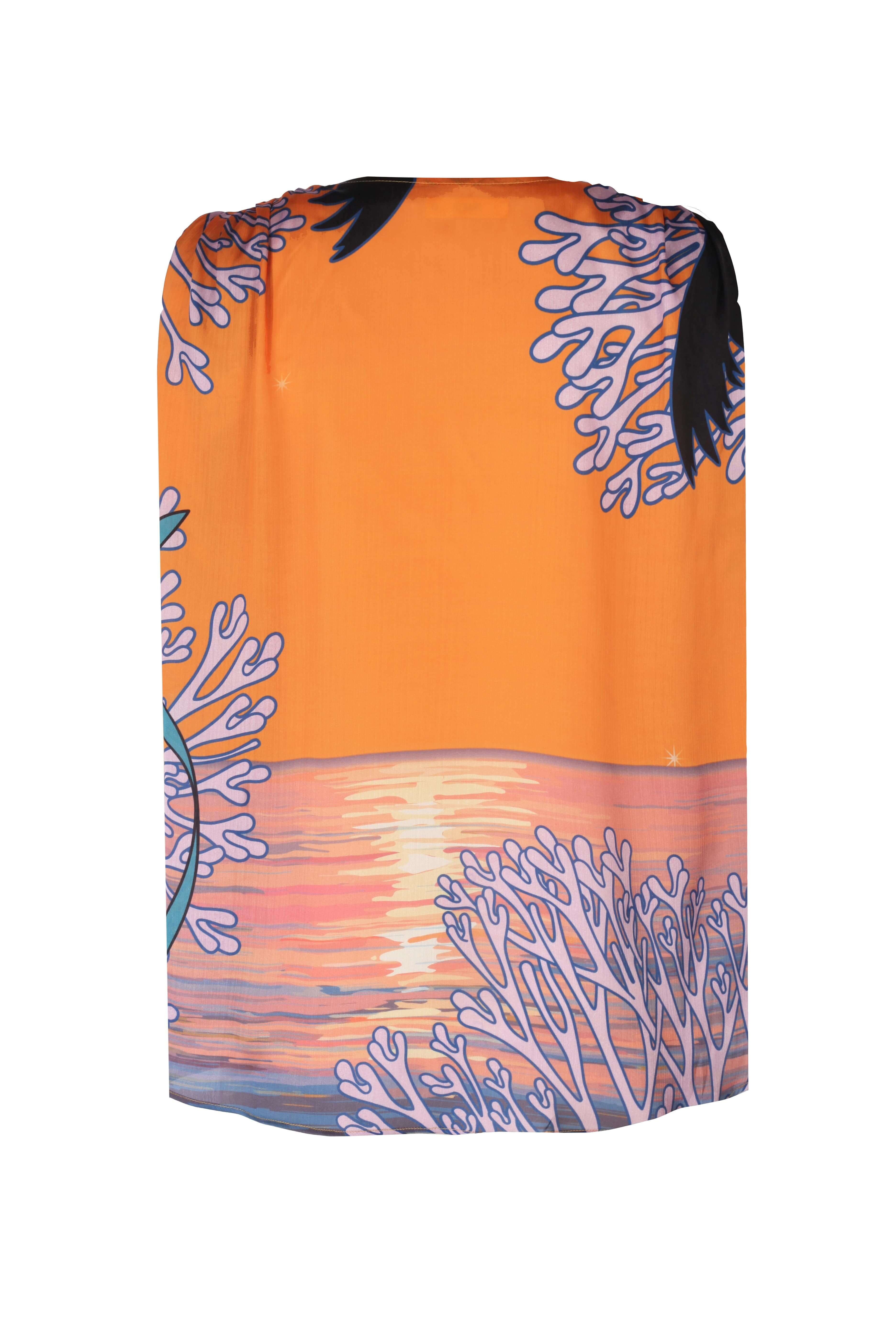 Back view of the vibrant ORLA SHIRT featuring colorful coral designs against a sunset backdrop.